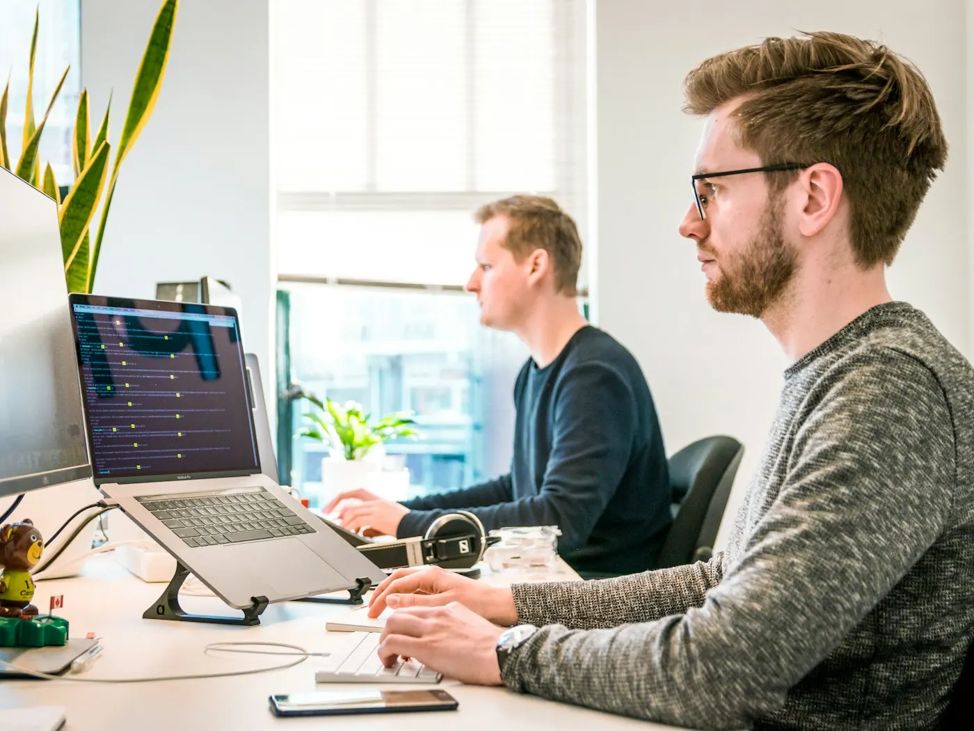Two people building a client system at a desk