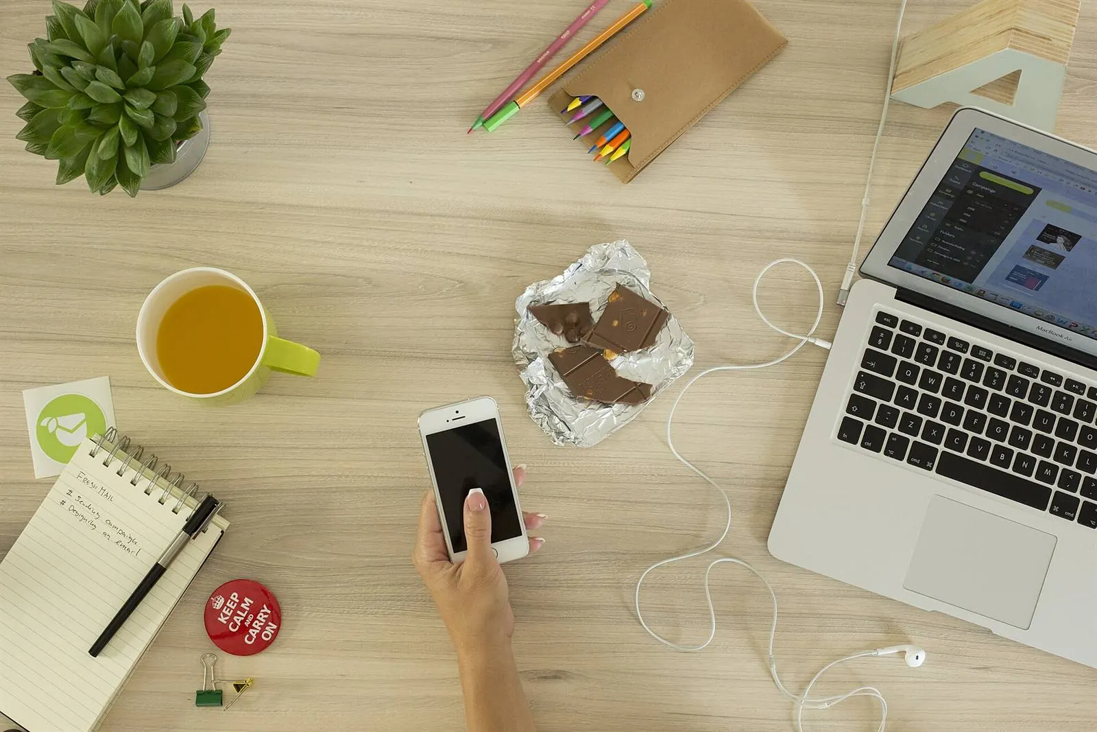 One work desk with a laptop, a phone and a notebook